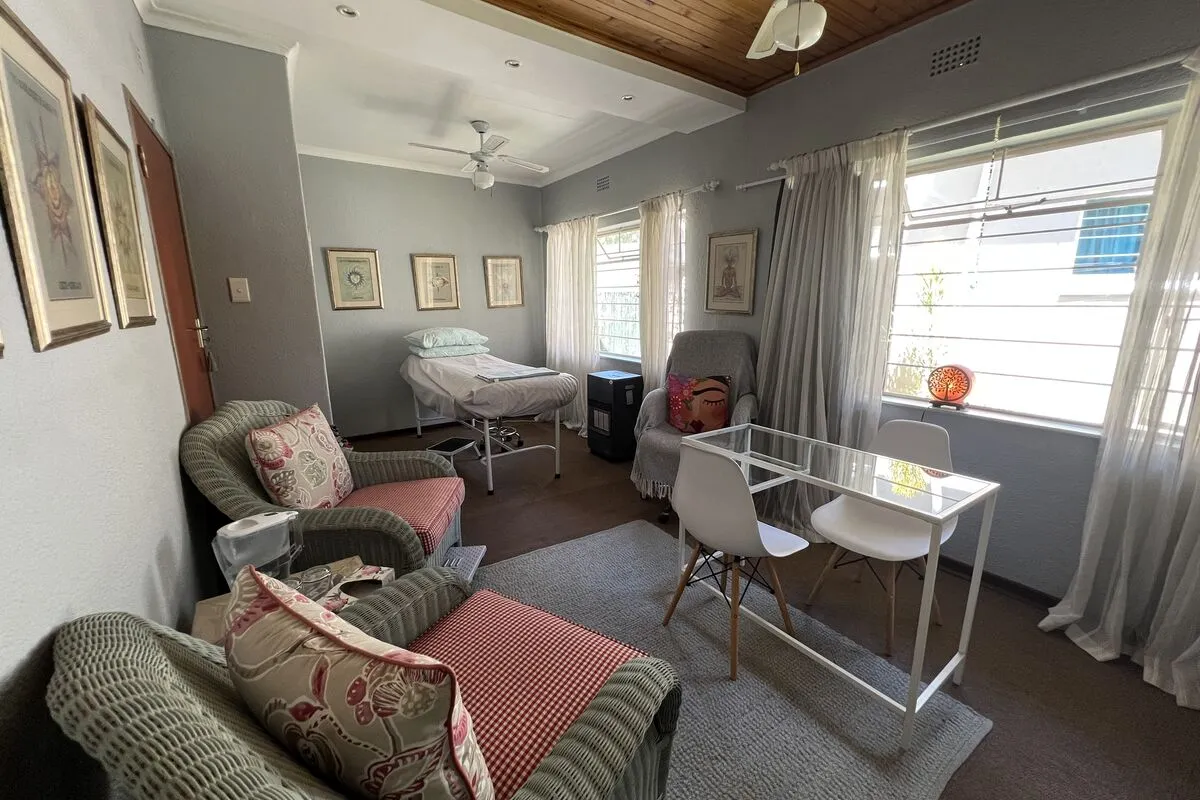 A consultation room with armchairs, a glass table and large windows