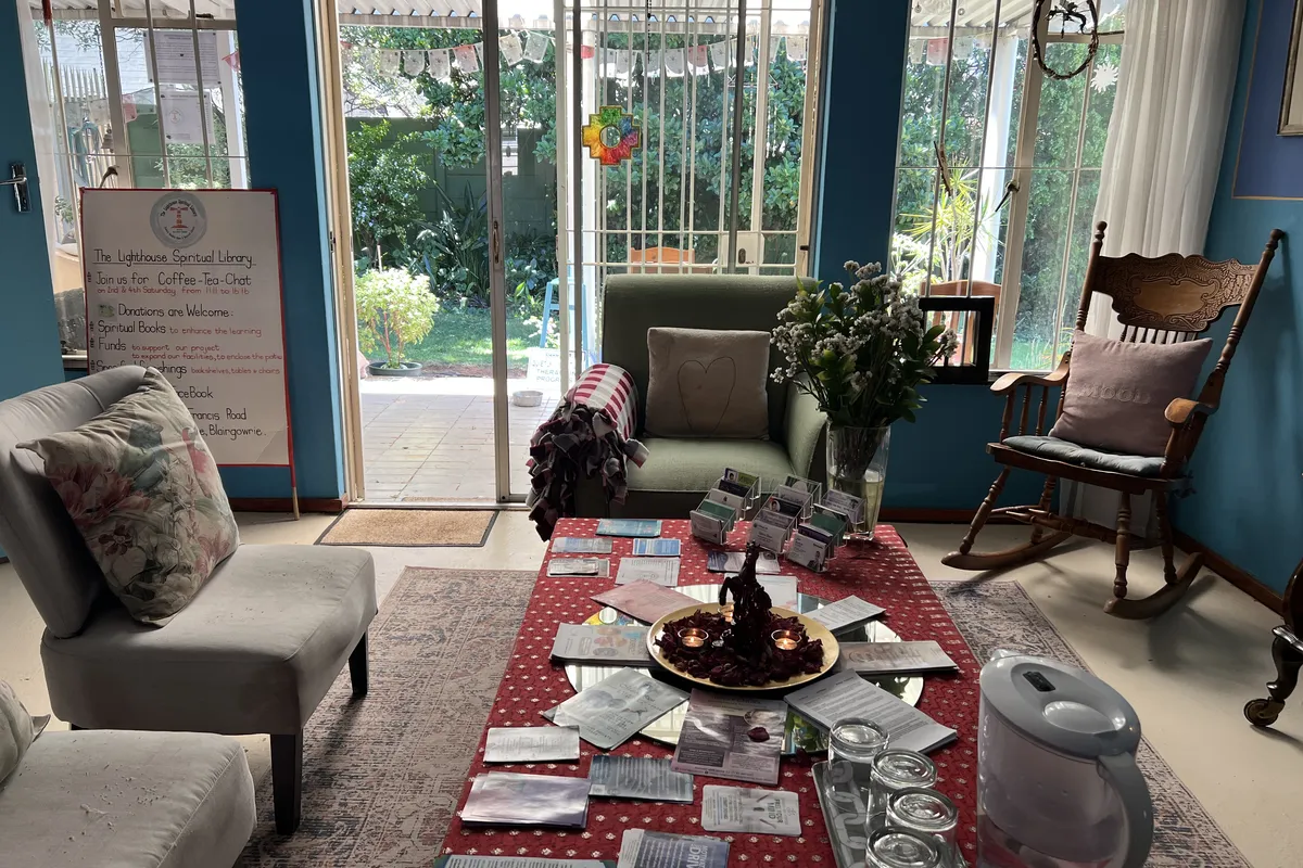 The sitting room: armchairs and a low table with a view through open glass doors to the garden